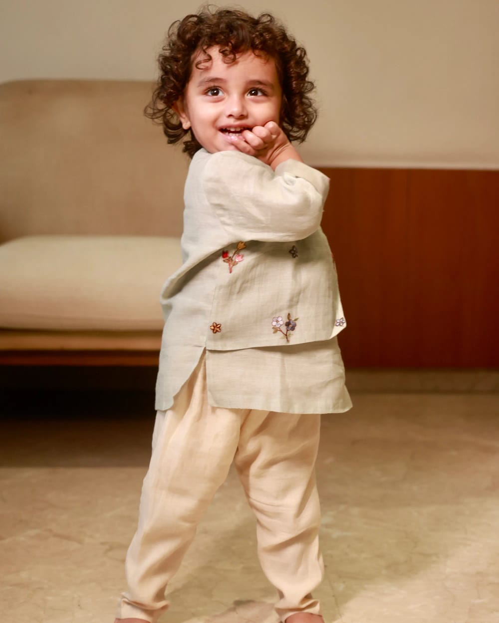 The oatmeal kurta from the front, small embroidered flowers scattered across it