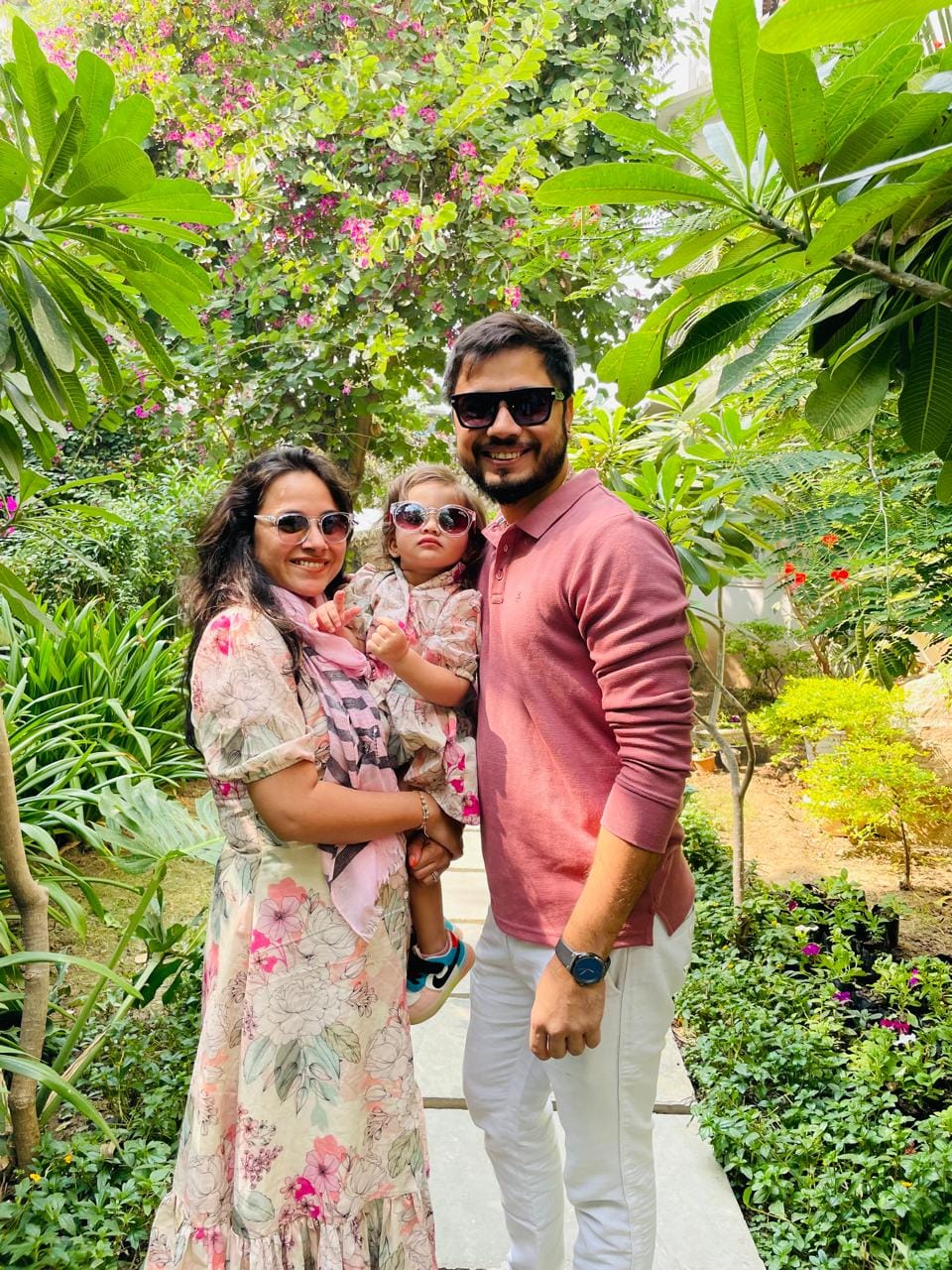 Charmi and her brother Utsav, who design and run kachche dhaage, with one of Charmi's children in a garden